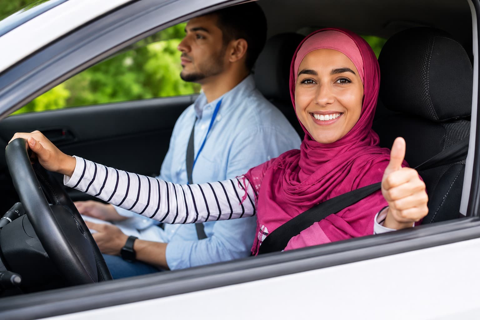 A parent handing car keys to their teen in a driveway
